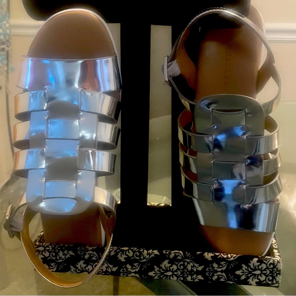 A silver metallic pair of metallic Roman gladiator sandals